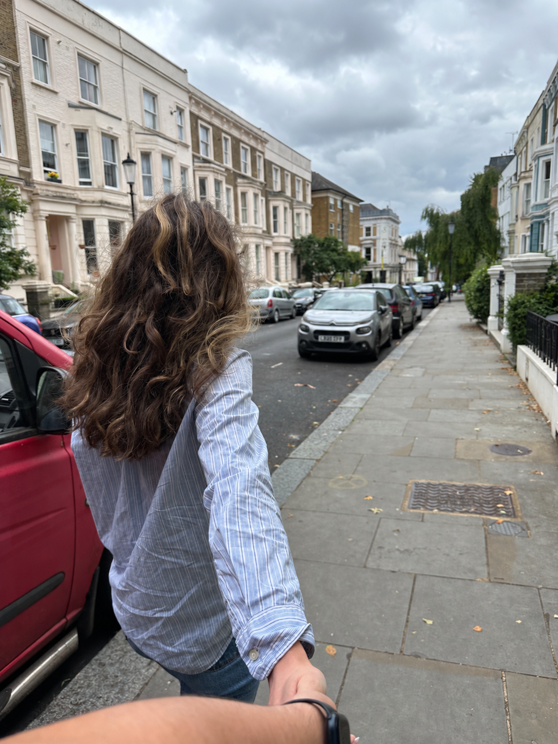 Holding hands walking through a London street