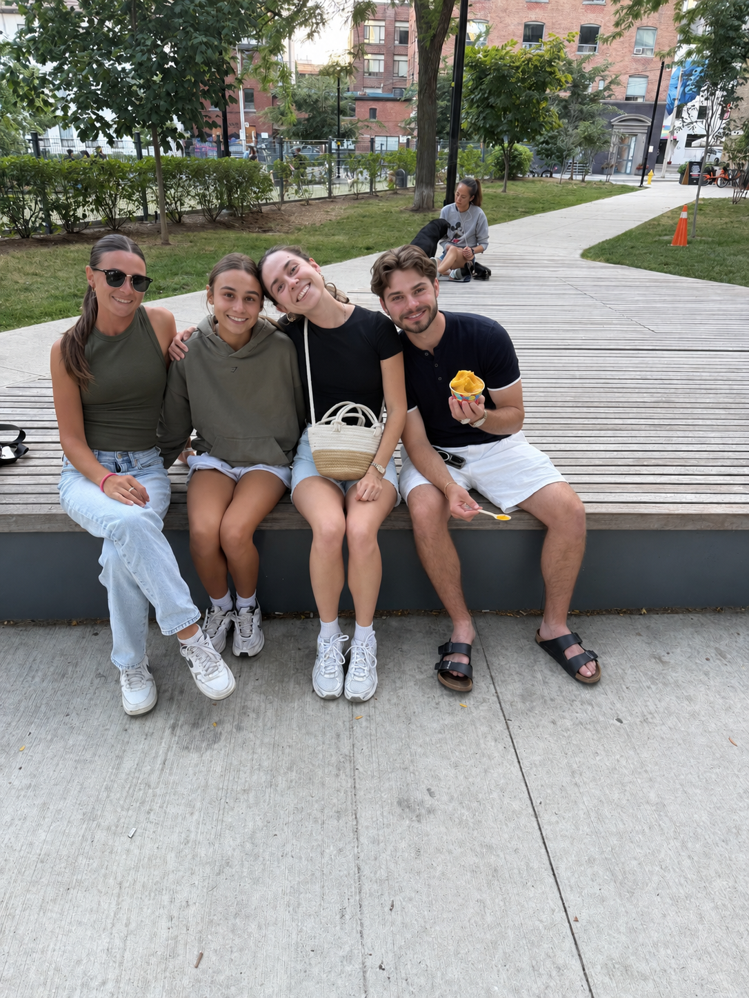 Friends sharing frozen custard on a park bench